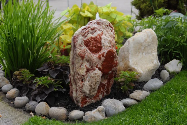 Natural onyx water feature among garden planting
