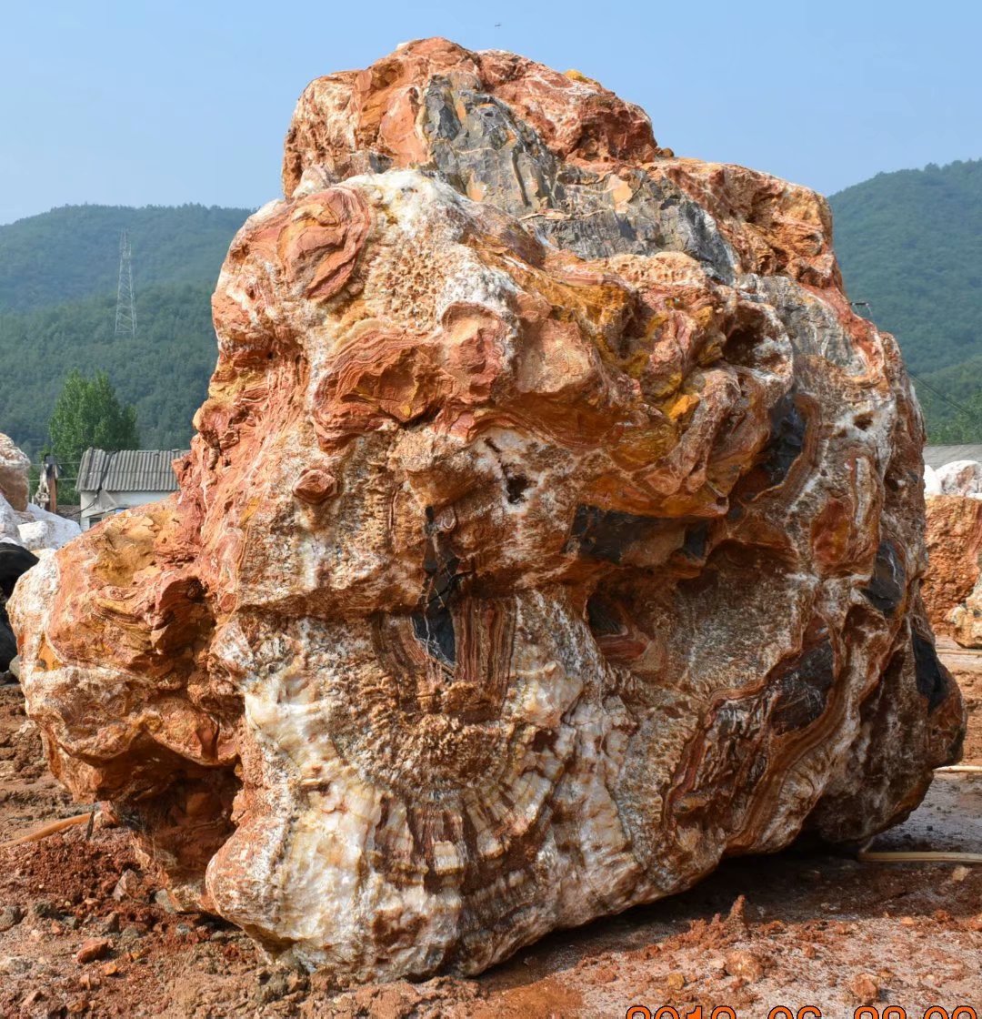 Sculptural natural stone with red, gold and cream veining